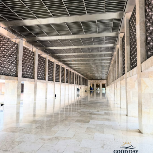 Long marble corridor inside Istiqlal Mosque Jakarta featuring modern Islamic architecture, symmetrical pillars, geometric wall patterns, and spacious prayer hall design in Jakarta, Indonesia.