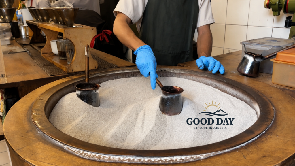 Traditional Indonesian coffee brewing process at a café in Glodok Jakarta, featuring coffee pots heated in hot sand and handcrafted manual brew techniques inside a vintage coffee shop.