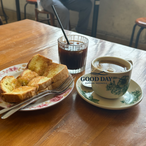 Traditional Indonesian black coffee served with crispy kaya toast on a wooden table inside a vintage café in Glodok Jakarta, creating a cozy old-town coffee shop atmosphere