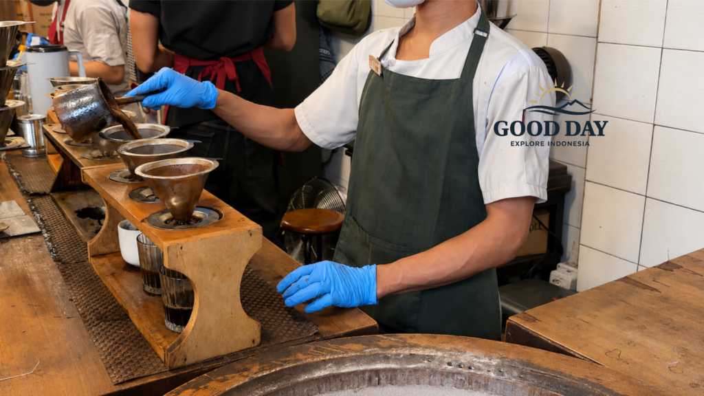 Barista preparing traditional manual brew coffee at a café in Glodok Jakarta, using metal coffee drippers and pour-over techniques inside a cozy vintage coffee shop.