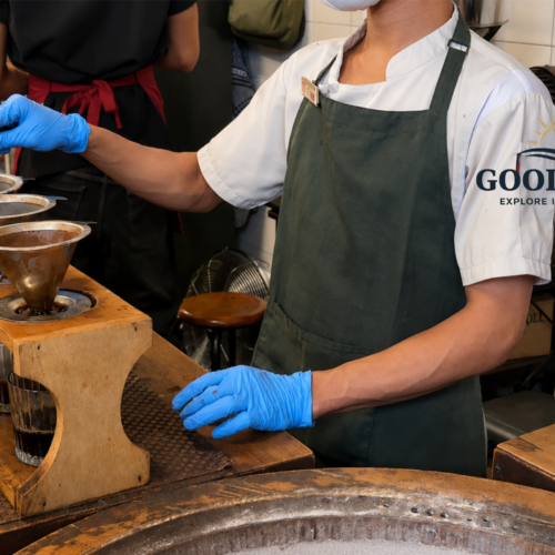 Barista preparing traditional manual brew coffee at a café in Glodok Jakarta, using metal coffee drippers and pour-over techniques inside a cozy vintage coffee shop.