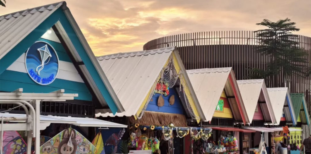 Colorful beachside souvenir shops at Aloha PIK Jakarta during sunset, featuring local merchandise, kites, and a tropical coastal atmosphere in Pantai Indah Kapuk.