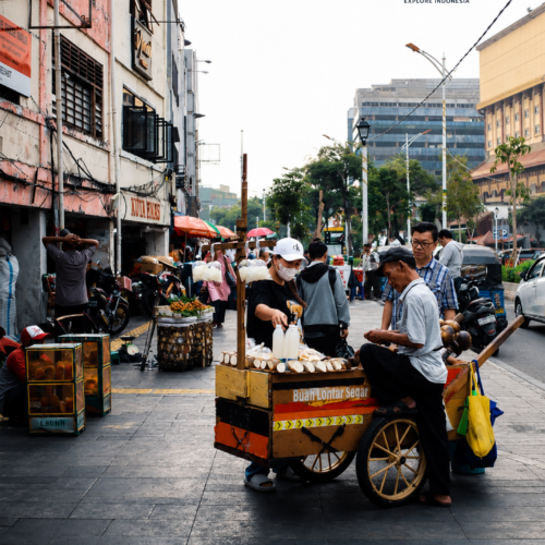 A traditional street vendor selling fresh lontar palm fruit drinks in Glodok Chinatown, Jakarta, surrounded by local shoppers and historic urban streets.