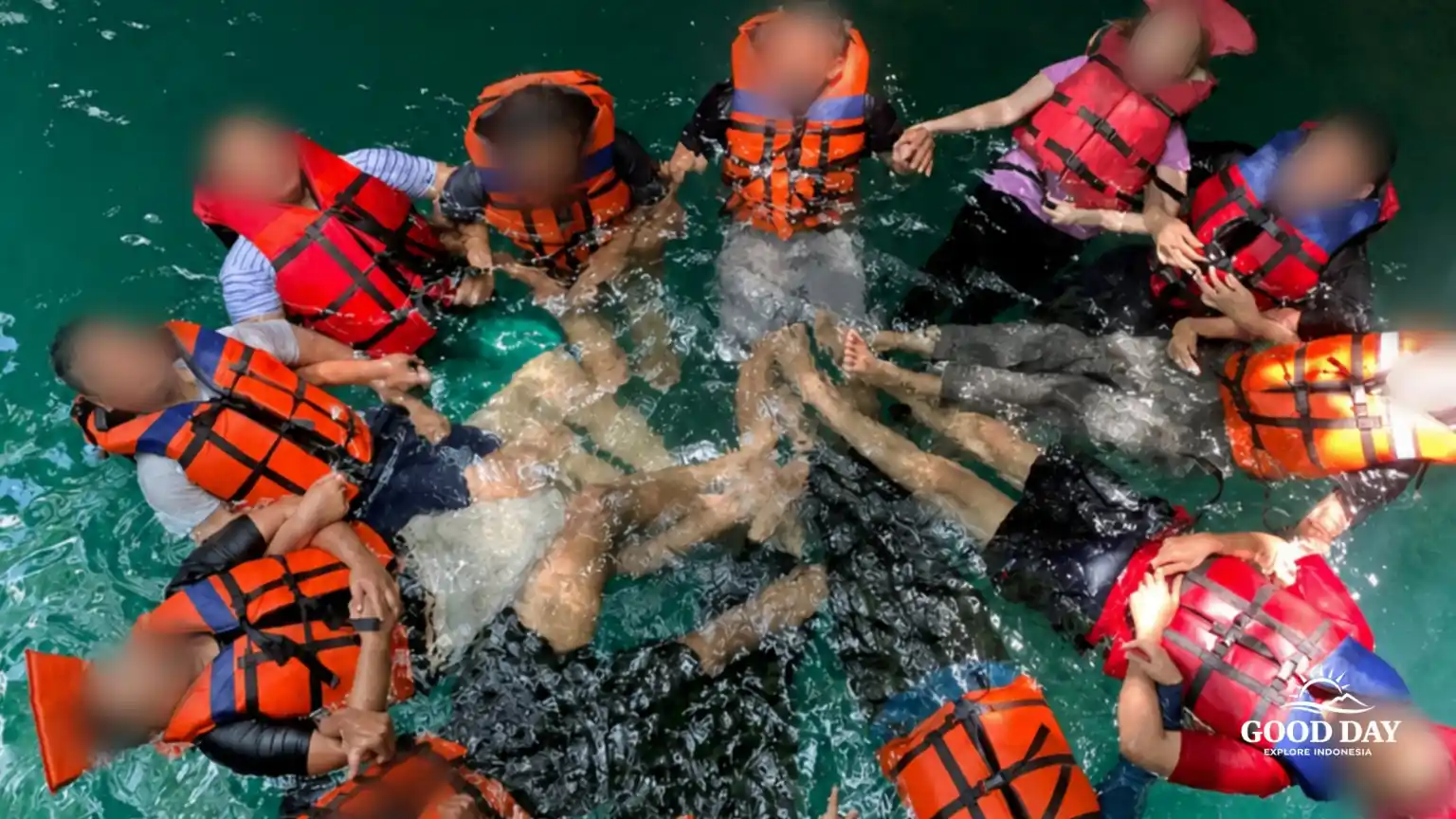 Participants enjoying a body rafting adventure in the crystal-clear natural pools of Curug Naga Waterfall, Bogor, West Java, Indonesia.