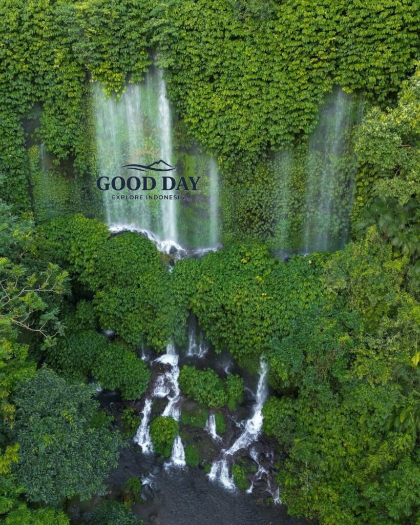 Benang Kelambu Waterfall in Lombok, Indonesia, featuring multiple streams of water flowing through lush green tropical vegetation and cascading over moss-covered cliffs in a pristine rainforest setting.
