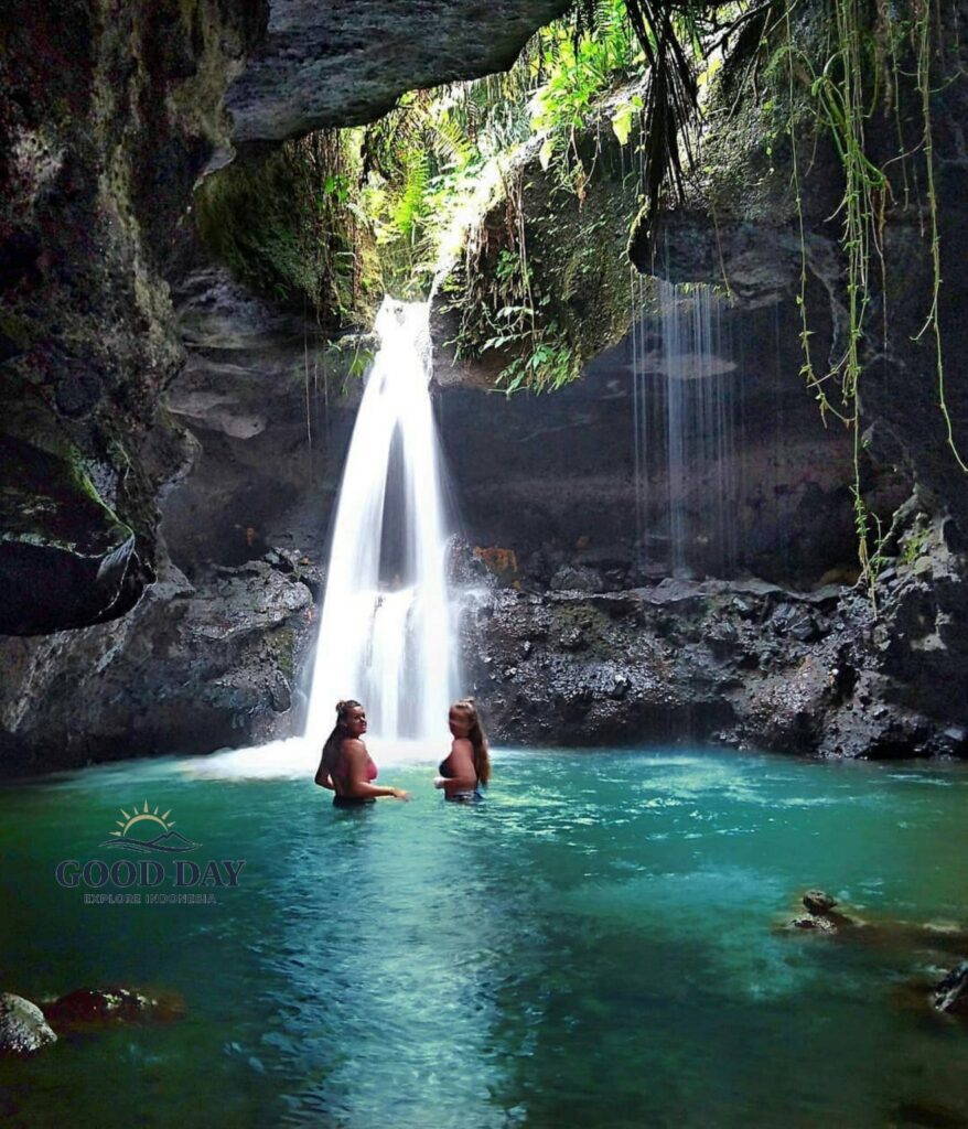 Burung Walet Waterfall in Lombok, Indonesia, featuring a hidden cave-like canyon, crystal-clear turquoise pool, and visitors enjoying a swim beneath a cascading tropical waterfall surrounded by lush jungle vegetation.