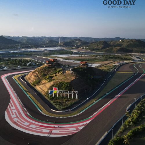 Aerial view of Pertamina Mandalika International Circuit in Lombok, Indonesia, showcasing its iconic sweeping corner, modern race track layout, and scenic hills surrounding the world-class motorsport venue in the Mandalika Special Economic Zone.