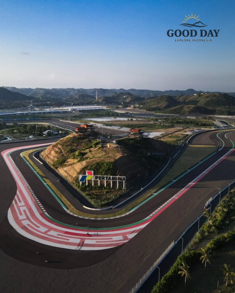 Aerial view of Pertamina Mandalika International Circuit in Lombok, Indonesia, showcasing its iconic sweeping corner, modern race track layout, and scenic hills surrounding the world-class motorsport venue in the Mandalika Special Economic Zone.