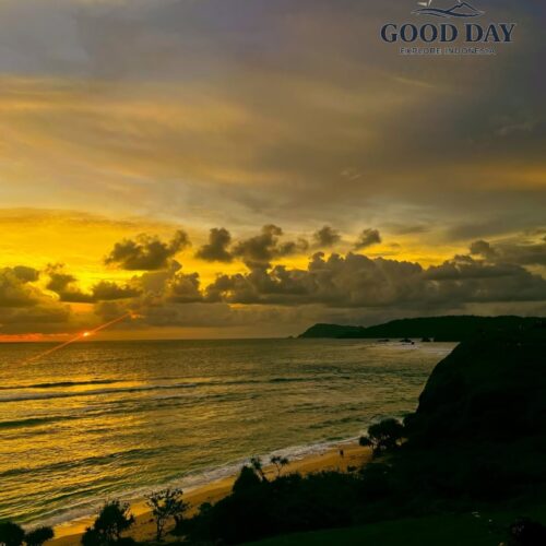 Sunset view from Merese Hill in Lombok, Indonesia, overlooking the Indian Ocean with golden sunlight reflecting on the waves, dramatic clouds, rugged coastal cliffs, and a pristine beach below.