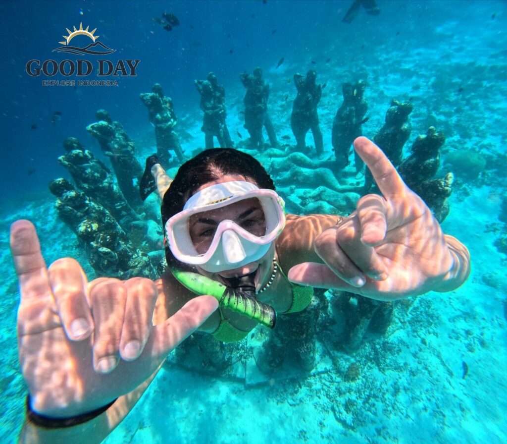Snorkeler exploring the famous underwater statues at Gili Meno, Lombok, Indonesia. Surrounded by crystal-clear turquoise water and marine life, the diver poses in front of the iconic underwater sculpture installation, one of the most popular snorkeling attractions in the Gili Islands.