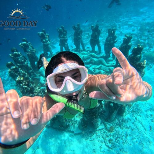 Snorkeler exploring the famous underwater statues at Gili Meno, Lombok, Indonesia. Surrounded by crystal-clear turquoise water and marine life, the diver poses in front of the iconic underwater sculpture installation, one of the most popular snorkeling attractions in the Gili Islands.