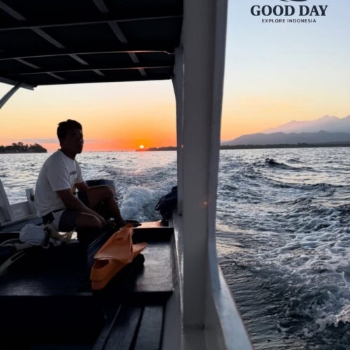 Traditional boat ride at sunset in Lombok, Indonesia, with golden sunlight reflecting on the ocean and views of Mount Rinjani in the distance, creating a peaceful island travel experience.