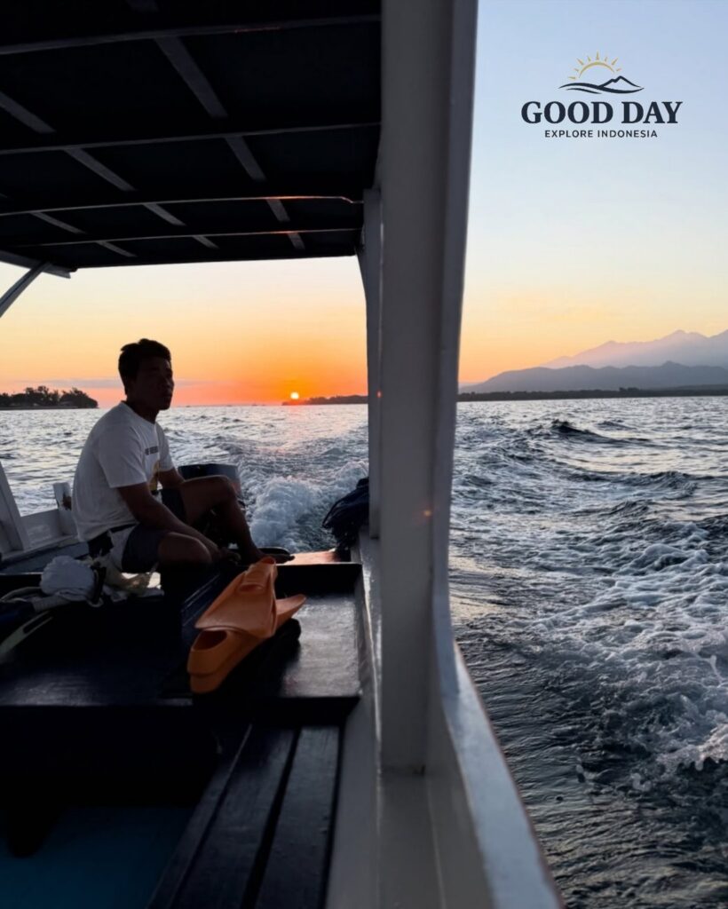 Traditional boat ride at sunset in Lombok, Indonesia, with golden sunlight reflecting on the ocean and views of Mount Rinjani in the distance, creating a peaceful island travel experience.