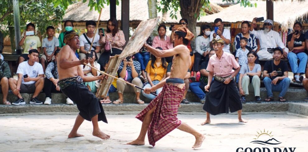 Traditional Peresean stick-fighting performance in Sade Traditional Village, Lombok, Indonesia. Sasak warriors wearing traditional sarongs engage in a cultural martial arts demonstration while visitors watch and learn about Lombok’s rich indigenous heritage.