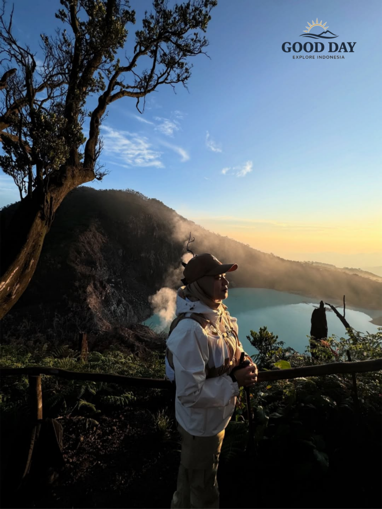 Traveler enjoying a golden sunrise at Sunan Ibu Viewpoint overlooking the turquoise volcanic crater lake of Kawah Putih in Ciwidey, Bandung, West Java, Indonesia.