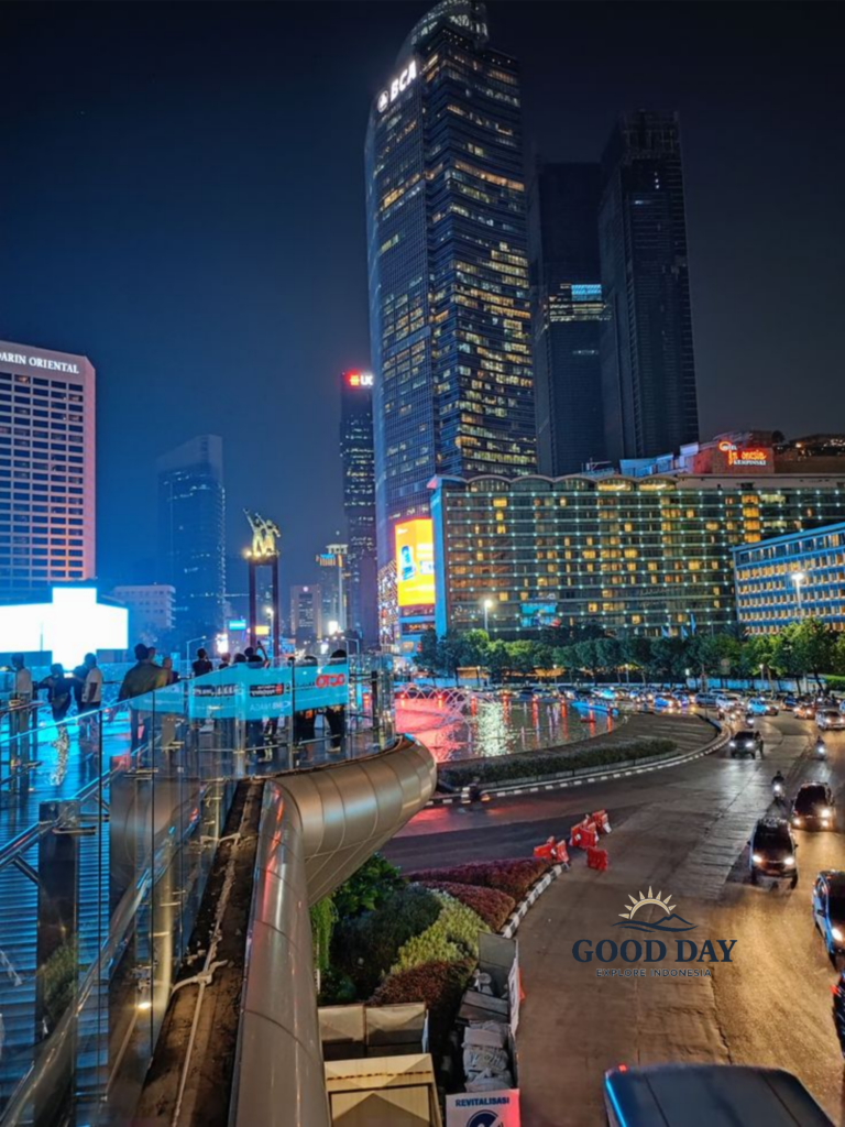 undaran HI Jakarta at night featuring the iconic Hotel Indonesia Roundabout, illuminated skyscrapers, vibrant city lights, and busy traffic in the heart of Indonesia’s capital city. The modern skyline creates a dynamic urban atmosphere in Jakarta’s central business district.