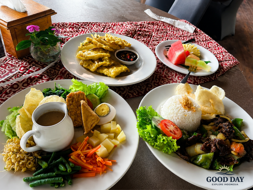 Traditional Indonesian cuisine served in Yogyakarta, featuring Gudeg, Nasi Campur, stir-fried beef with vegetables, fried snacks, fresh tropical fruits, and authentic Javanese dishes beautifully presented on a dining table.