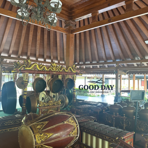 Traditional Javanese gamelan orchestra set inside a historic wooden pendopo in Yogyakarta, Indonesia. The ensemble features bronze gongs, metallophones, kendang drums, and intricately carved wooden decorations beneath a classic Joglo-style roof, showcasing the rich cultural heritage of Java.