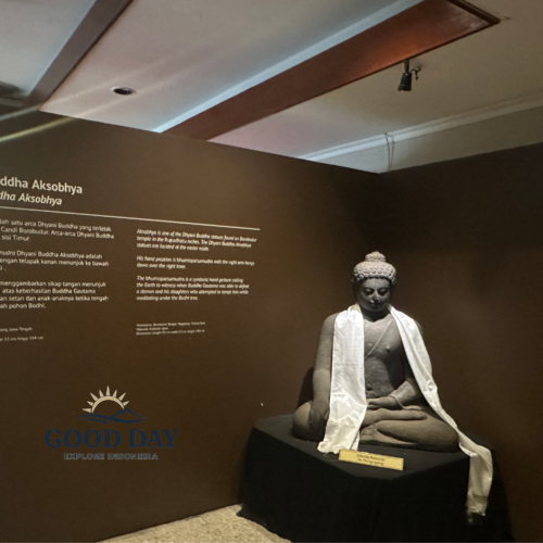 Dhyani Buddha Akshobhya statue displayed inside the Borobudur Museum in Yogyakarta, Indonesia. The ancient Buddhist sculpture is showcased in an exhibition space with informative panels explaining its historical, spiritual, and cultural significance within Borobudur Temple.