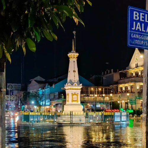 Tugu Yogyakarta illuminated at night in the heart of Yogyakarta, Indonesia, showcasing the city's iconic white monument surrounded by vibrant urban lights and historic streets.