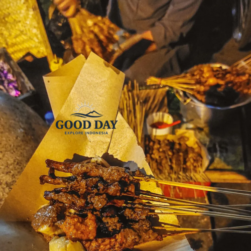 Traditional satay skewers being freshly grilled and served at a street food stall in Malioboro, Yogyakarta, Indonesia, showcasing one of the city's most popular night market culinary experiences.