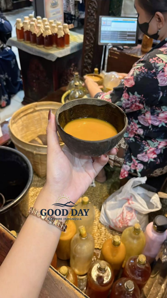 A traditional glass of Jamu, Indonesia's herbal wellness drink, being served at a local market in Yogyakarta, surrounded by handmade bottles of natural herbal beverages.