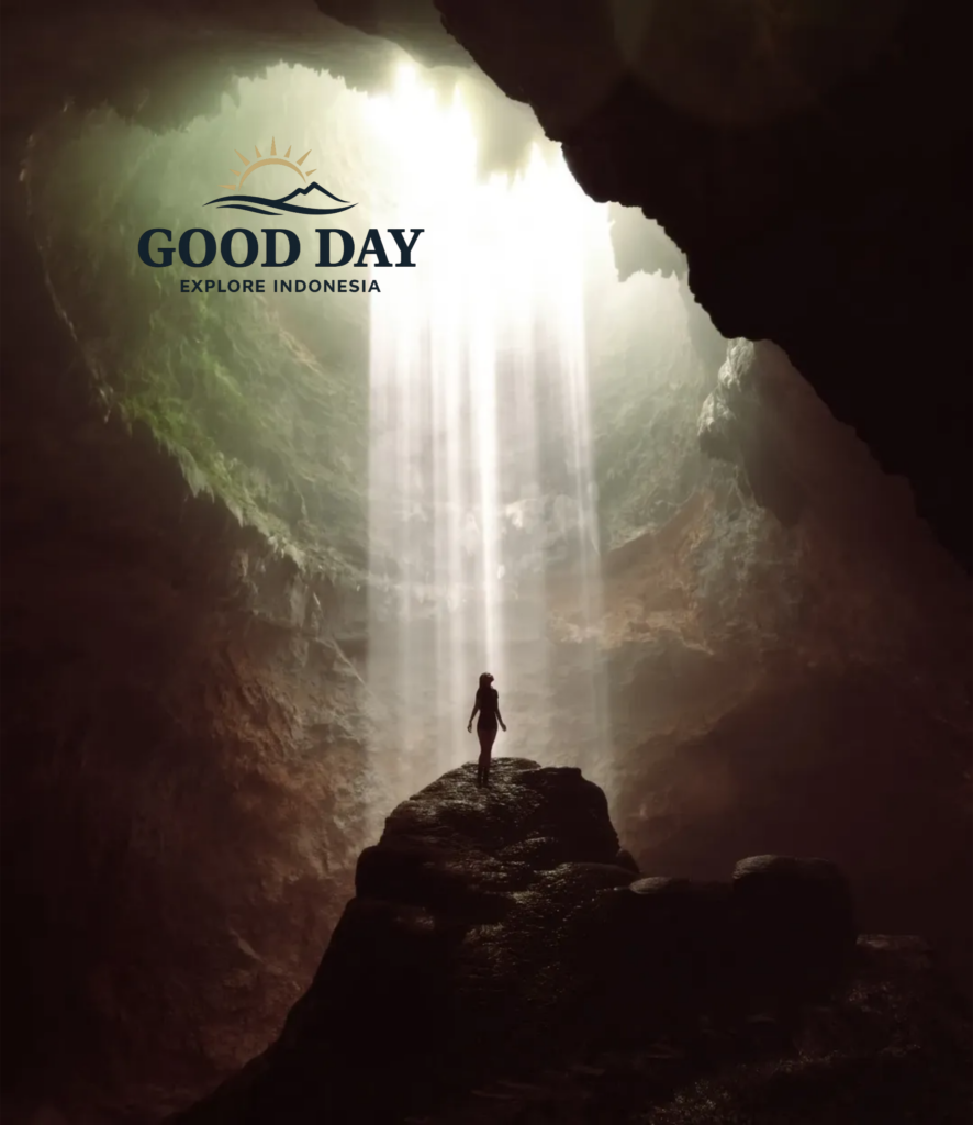 A traveler standing beneath the famous Heaven's Light inside Jomblang Cave, Yogyakarta, Indonesia, as powerful beams of sunlight pour through the cave opening and illuminate the massive underground chamber.