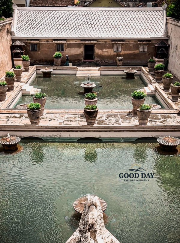 Aerial view of the historic bathing pools at Taman Sari Water Castle in Yogyakarta, Indonesia, featuring elegant fountains, tranquil water basins, and traditional Javanese royal architecture within the former palace complex.
