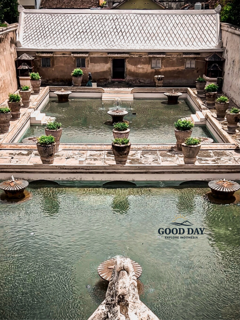 Aerial view of the historic bathing pools at Taman Sari Water Castle in Yogyakarta, Indonesia, featuring elegant fountains, tranquil water basins, and traditional Javanese royal architecture within the former palace complex.