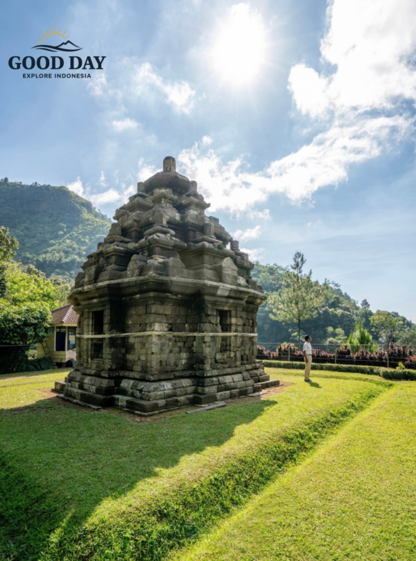Ancient Selogriyo Temple standing amidst lush green hills under a bright blue sky in Magelang near Yogyakarta, showcasing classic Hindu temple architecture surrounded by peaceful natural landscapes.