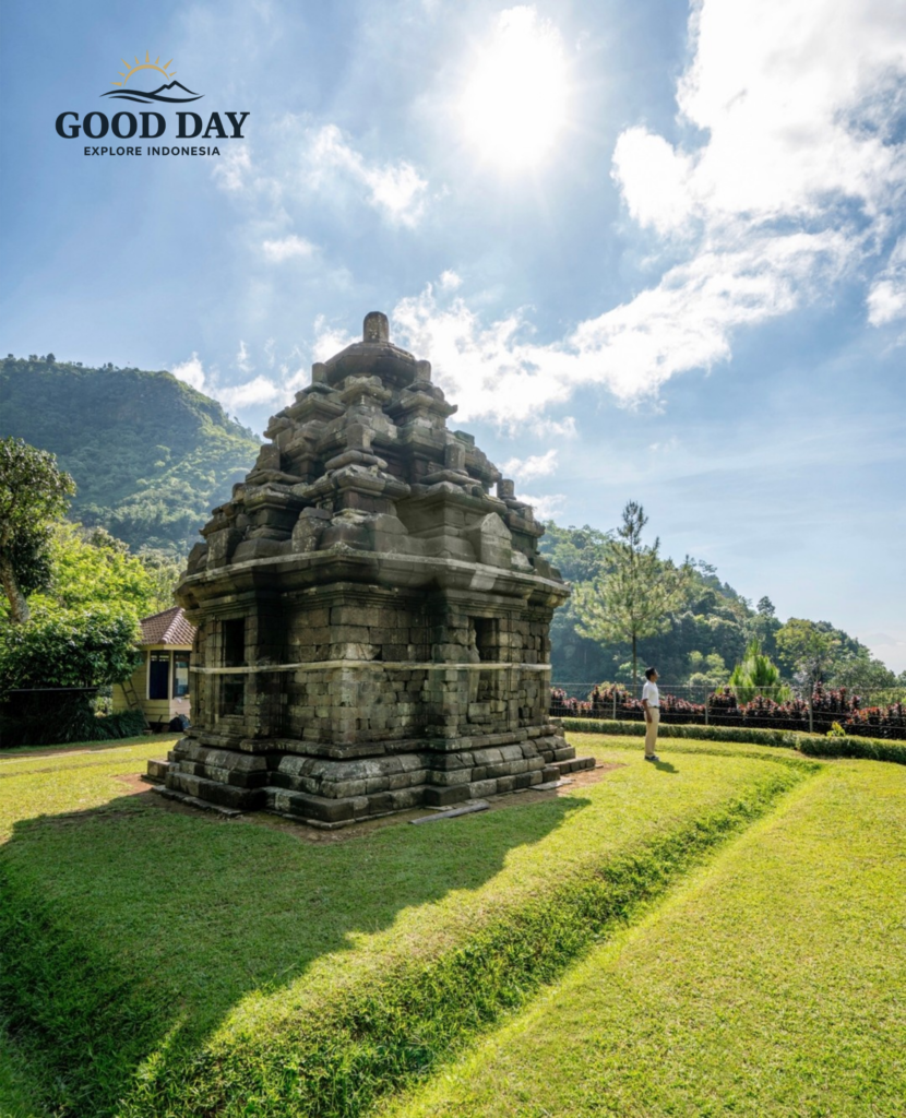 Ancient Selogriyo Temple standing amidst lush green hills under a bright blue sky in Magelang near Yogyakarta, showcasing classic Hindu temple architecture surrounded by peaceful natural landscapes.