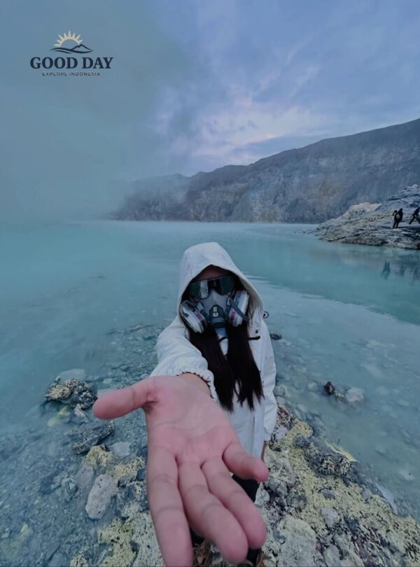 Traveler wearing a gas mask and protective clothing at Kawah Ijen Crater Lake, Banyuwangi, East Java, Indonesia. The turquoise volcanic lake, sulfur mist, and dramatic crater landscape create a unique adventure experience at Mount Ijen.