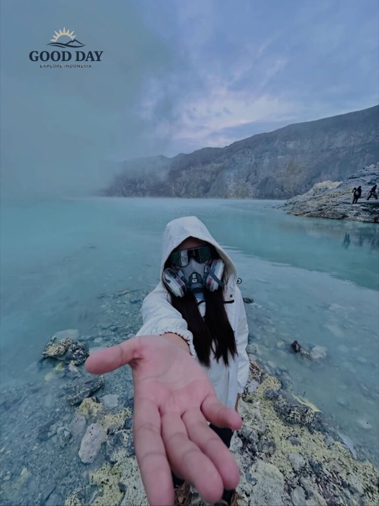 Traveler wearing a gas mask and protective clothing at Kawah Ijen Crater Lake, Banyuwangi, East Java, Indonesia. The turquoise volcanic lake, sulfur mist, and dramatic crater landscape create a unique adventure experience at Mount Ijen.