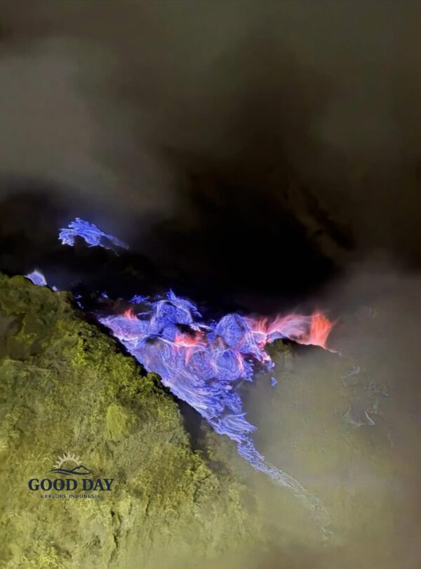Blue fire phenomenon at Kawah Ijen, Banyuwangi, East Java, Indonesia. Electric-blue flames emerge from sulfur deposits in the volcanic crater at night, surrounded by thick smoke and rugged volcanic rocks.