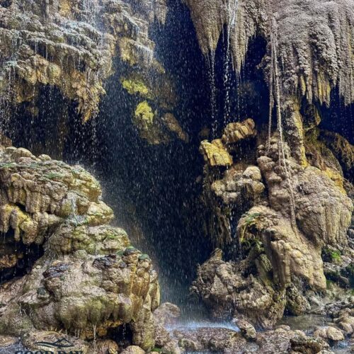 Detailed view of limestone formations inside Goa Tetes Lumajang with crystal-clear water droplets cascading over natural rock terraces, creating a stunning cave waterfall landscape in East Java, Indonesia.