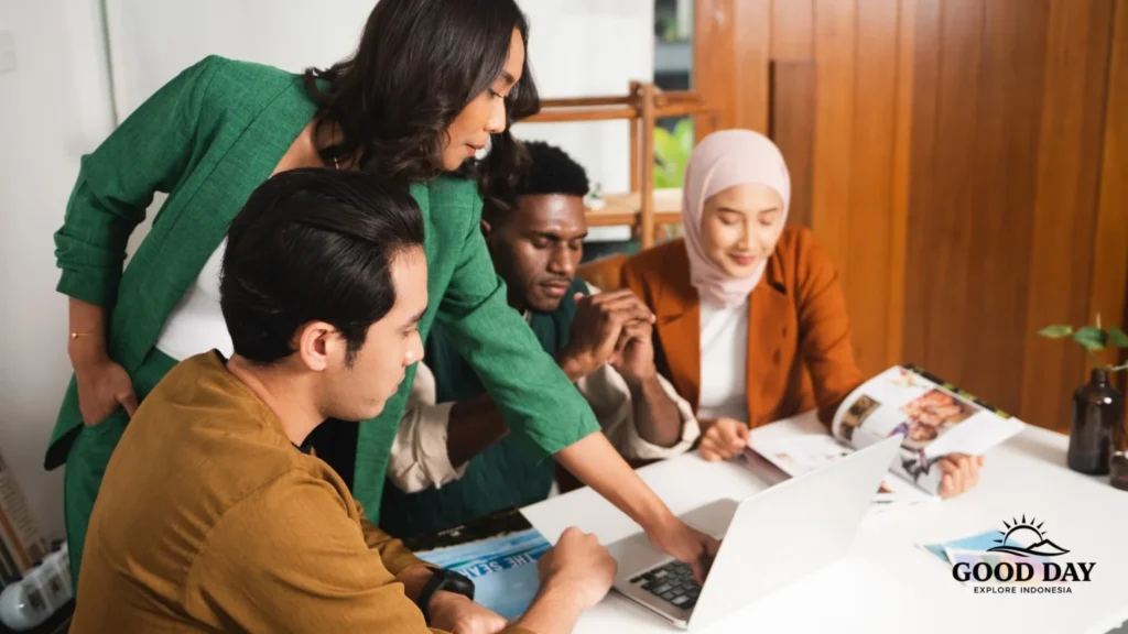 A diverse business team collaborating during a corporate meeting in Indonesia, discussing strategy and planning with a laptop in a modern office.