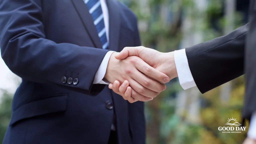 Business negotiation in Jakarta, Indonesia, with professionals shaking hands after a successful corporate meeting and partnership discussion.