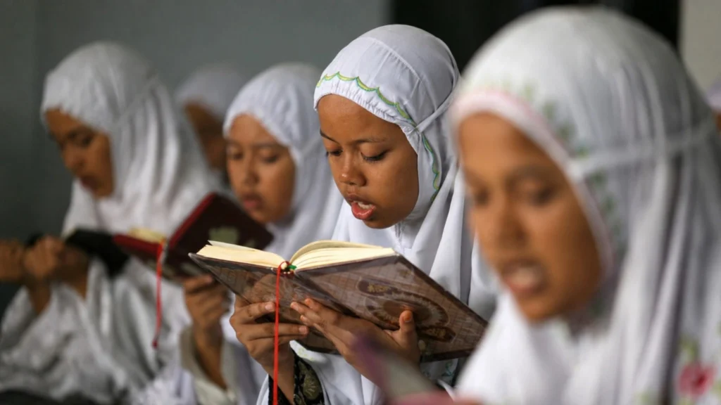 Indonesian Muslim children reading the Quran together during an Islamic study session at a local religious school in Indonesia.