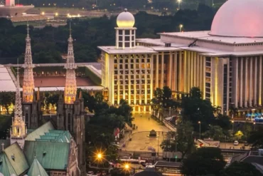 Aerial view of Istiqlal Mosque and Jakarta Cathedral standing opposite each other in Central Jakarta, Indonesia, symbolizing religious harmony and mutual respect.