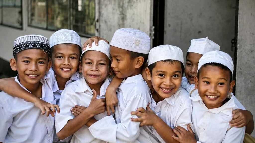 Portrait of smiling Indonesian Muslim children wearing traditional Islamic caps while gathering together in Indonesia.